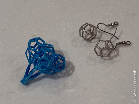 A tree of four resin dodecahedra next to two silver earrings with dodecahedra